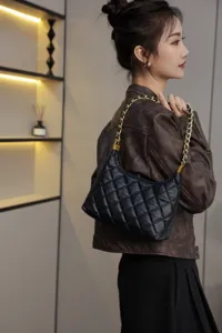 Black quilted leather shoulder bag underarm bag with gold chain strap detail showcase