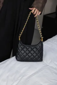 Genuine leather quilted shoulder bag for women, elegant black underarm bag with gold chain.