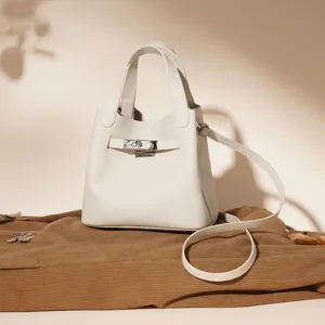 Beau sac a main blanc en cuir veritable avec fermoir tournant pour femmes elegantes.