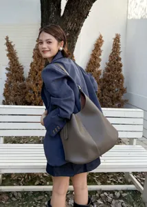 Detail view of the stylish genuine leather hobo shoulder bag with contrast stitching design.