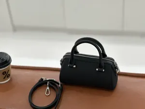 Black leather Boston handbag for women, mini pillow shoulder bag with detachable strap.