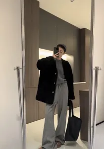 Primo piano della borsa tote minimalista in pelle nera abbinata a un outfit casual.