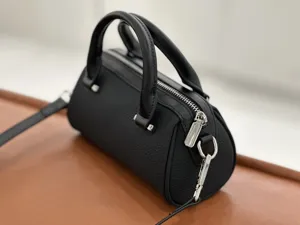 Close-up of black leather Boston handbag featuring top handles, silver hardware and zipper.