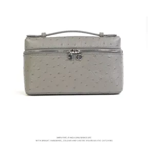 Detailed view of the luxury grey ostrich textured leather cosmetic bag with polished hardware.