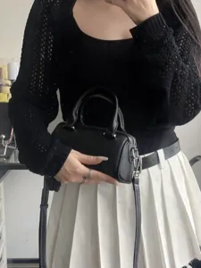 Black leather boston handbag for women, stylish small pillow shoulder bag with top handle.