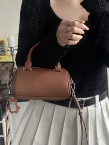 Stylish brown leather Boston bag for women, elegant top handle crossbody handbag with premium texture.