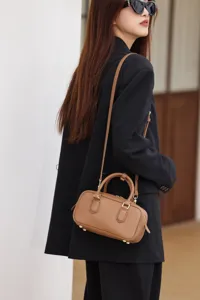 Small leather Boston bag for women, stylish niche pillow handbag with shoulder crossbody strap.