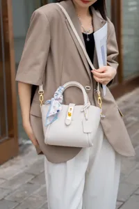 Borsa secchiello in vera pelle dettaglio, elegante borsa estiva con decorazione di sciarpa.