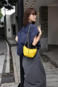 Chic yellow mini leather shoulder bag with chain strap, stylish lifestyle detail showcase.