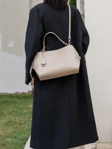 Elegant leather shoulder bag detail, stylish taupe handbag with metal hardware for daily commuting.