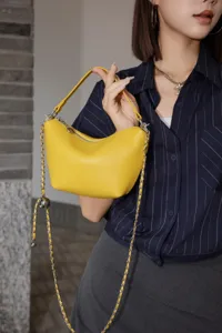 Yellow leather hobo bag detail shot, featuring soft cowhide texture and metallic chain strap.