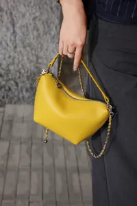 Genuine leather yellow mini shoulder bag with metal chain strap, chic crescent crossbody design.