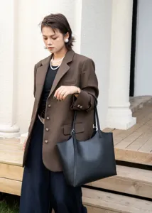 Close-up detail of the black leather tote bag showcasing premium texture and minimalist design.