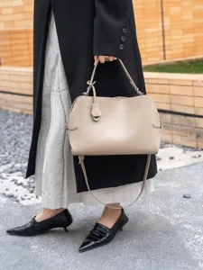 Detailed view of the premium leather shoulder handbag featuring elegant metal ring and strap.