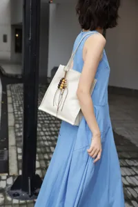 Detail view of the minimalist leather tote bag with stylish wooden bead charms for women.