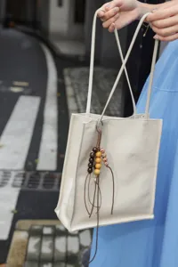 Genuine leather minimalist tote bag with chic beaded charm detail for daily commute.