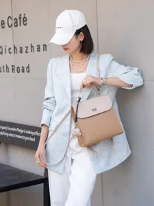 Primo piano dettagliato di un elegante zaino in pelle bicolore con chiusura in metallo.