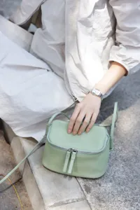 Genuine leather mini crossbody bag in light green, featuring a chic box design and fine strap.