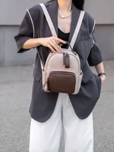 Primo piano dettagliato dello zaino in vera pelle bicolore con tasche multiple.