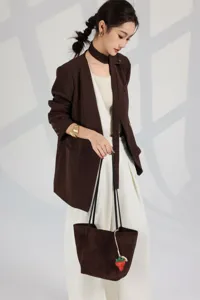 Detailed view of a chic brown suede tote bag styled with a professional casual outfit.