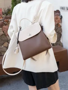 Vista dettagliata di un elegante zaino bicolore da donna in vera pelle, sfondo esterno chic.