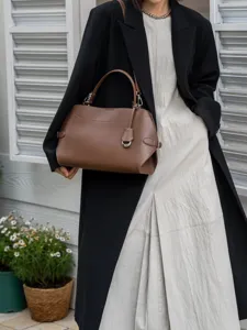 Detailed view of the brown leather commuting handbag showcasing its elegant texture and handle.