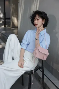 Pink leather crossbody mini bag detail, compact lunchbox design with smooth zipper closure.