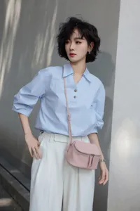 Pink genuine leather crossbody mini bag detail, showing compact dome shape and metal zip.