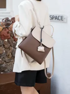 Dettaglio di un elegante zaino in pelle bicolore caratterizzato da toni marroni e beige.