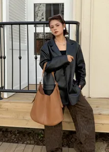 Brown leather hobo shoulder bag detail, showcasing soft texture, large capacity, minimalist design.