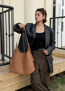 Detail shot of brown genuine leather hobo shoulder bag, large capacity slouchy tote style.