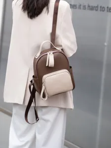 Dettaglio zaino in pelle con design bicolore e tasca frontale per viaggi e uso quotidiano.