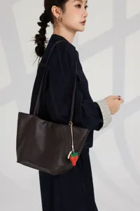 Premium genuine leather brown tote bag with cute strawberry charm for women daily fashion use.