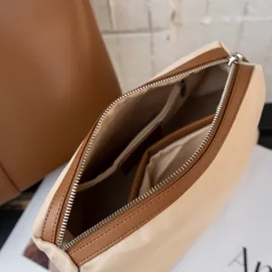 Vue détail trousse maquillage en toile, pochette zippée beige et marron avec compartiments.