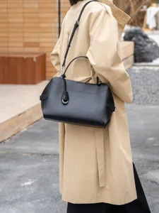 Black leather shoulder handbag detail, minimalist commuting tote bag with chic ring charm.