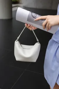 White leather mini shoulder bag detail, stylish dumpling handbag for women daily casual wear.