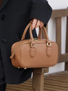 Brown leather Boston bag main view showing classic top handle design and gold hardware.