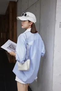 White leather minimalist shoulder bag with chain strap, stylish daily casual detail view.