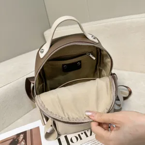 Dettaglio interno zaino in vera pelle bicolore con tasche multiple e consistenza morbida.