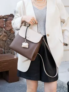 Zaino in pelle bicolore da donna, elegante borsa a spalla con manico e chiusura a patta.