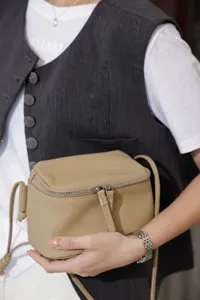Detailed view of the genuine leather mini crossbody bag featuring zipper and adjustable strap.
