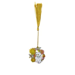 Close-up of a delicate metal cat bookmark with golden tassel and floral wreath design.