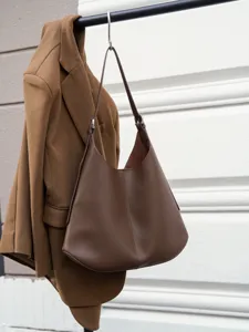 Brown leather shoulder bag hobo style tote detail view showing premium texture and strap.