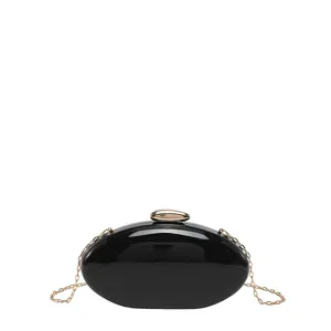 Black acrylic evening clutch bag with gold chain strap, elegant mango shape party bag.