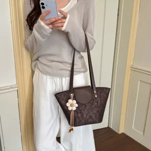 Chic brown leather tote bag with cute flower pendant, trendy minimalist shoulder bag for women.