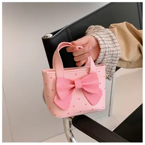 Schönes pinkes Pünktchen Handtaschen Detail mit großer Schleife und hellem Tragegriff.