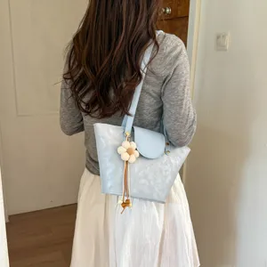 Back view detail of light blue stylish tote shoulder bag with cute flower pendant charm.