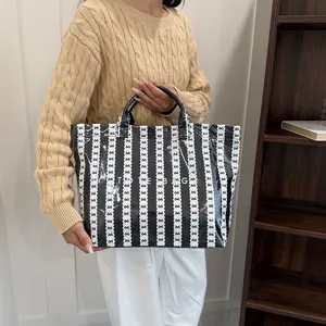 Stylish black and white bow pattern tote bag with large capacity, perfect for daily commuting.