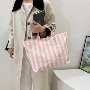 Detailed view of the pink striped canvas tote bag, featuring spacious casual commuter design.