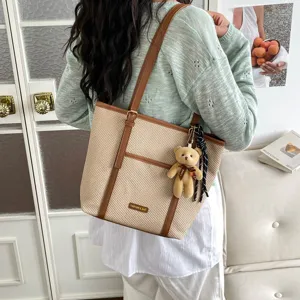 Retro commuter woven tote bag detail showing brown leather trim, shoulder strap and bear.